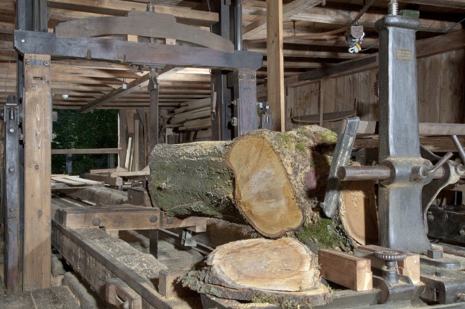 Erwähnenswert ist die über 100 Jahre alte Einfachgattersäge. Sie trennt pro Durchgang nur ein Brett vom Stamm. Dieser ist auf dem Blockwagen eingespannt, der nach jedem Schnitt in die Anfangsposition zurückgefahren wird, worauf wieder das nächste Brett gesägt werden kann.